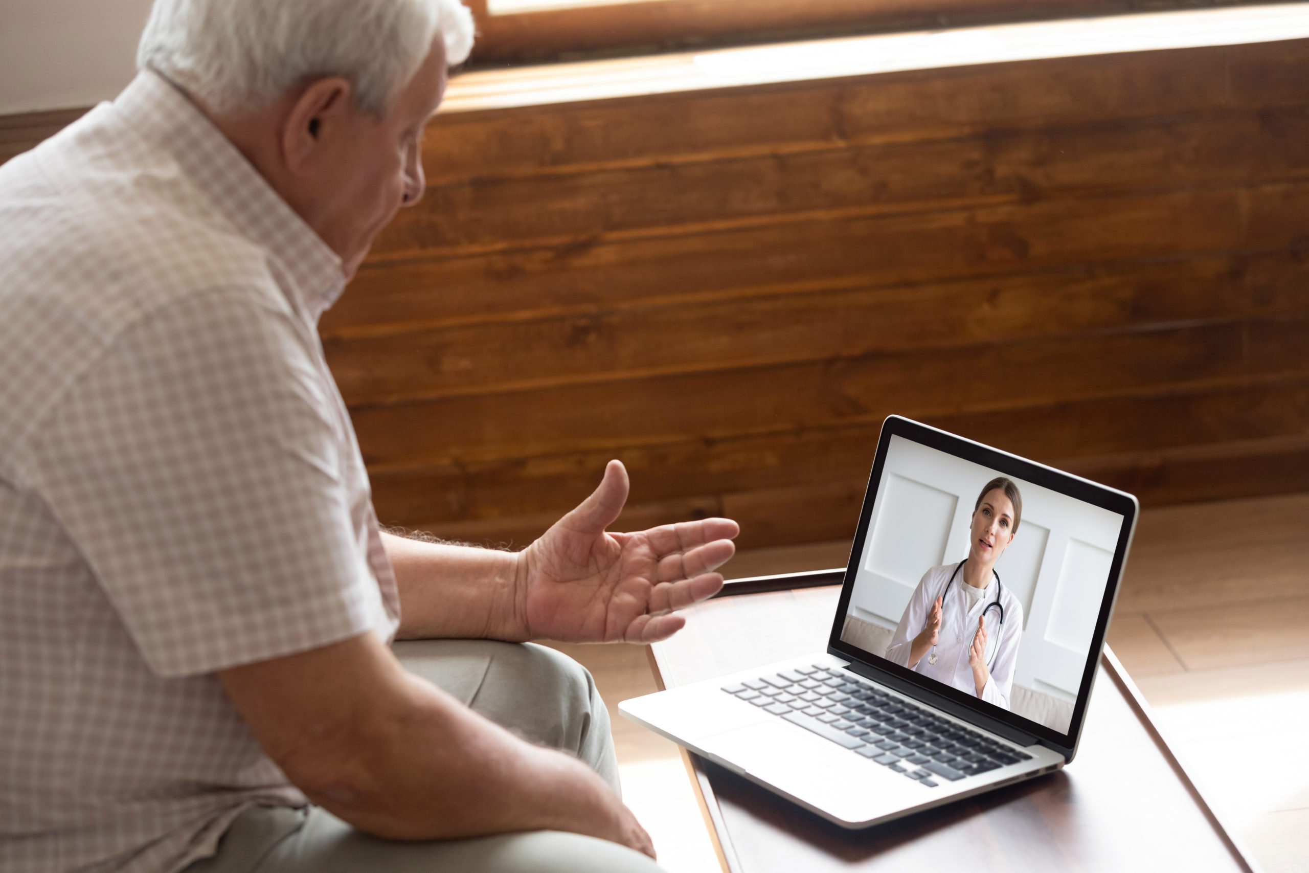 elderly man talking to a doctor at a walk in clinic via telehealth