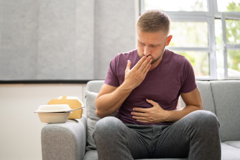 man having heartburn after eating large meal