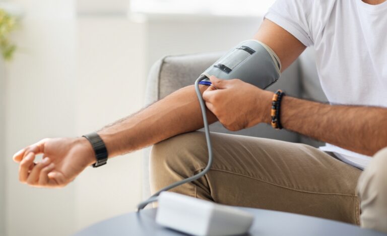 Person measuring blood pressure at home
