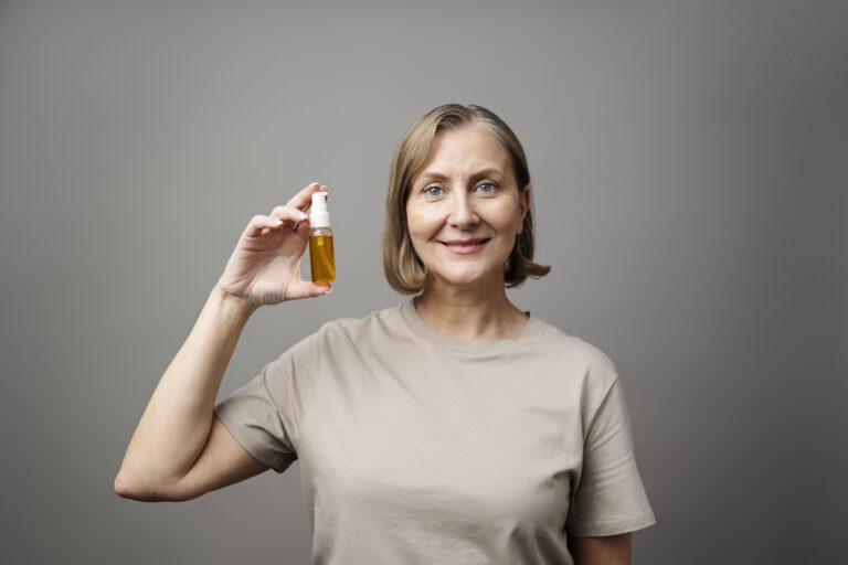 Woman holding serum bottle confidently.